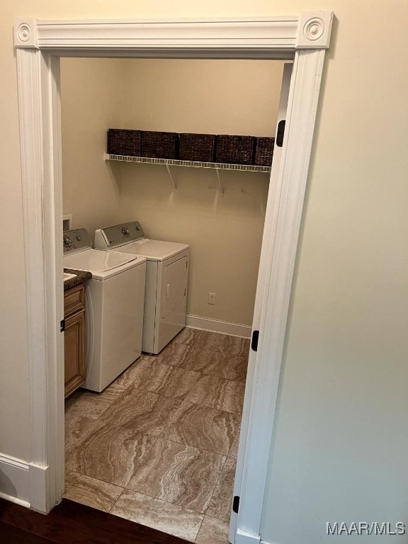 laundry room featuring cabinets and washer and clothes dryer