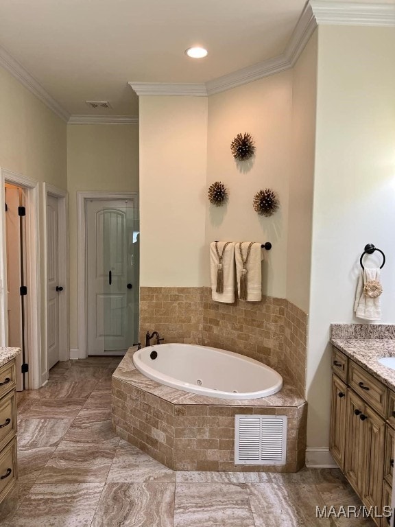 bathroom featuring tiled bath, vanity, and crown molding