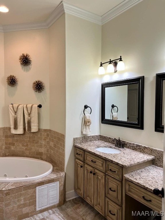 bathroom with crown molding, tiled tub, and vanity