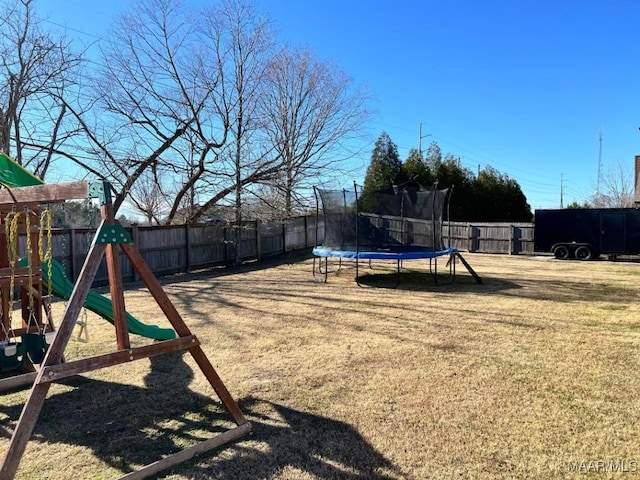 view of yard featuring a trampoline and a playground