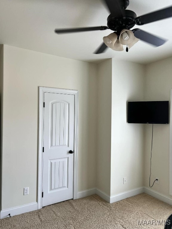 interior space featuring ceiling fan and light colored carpet