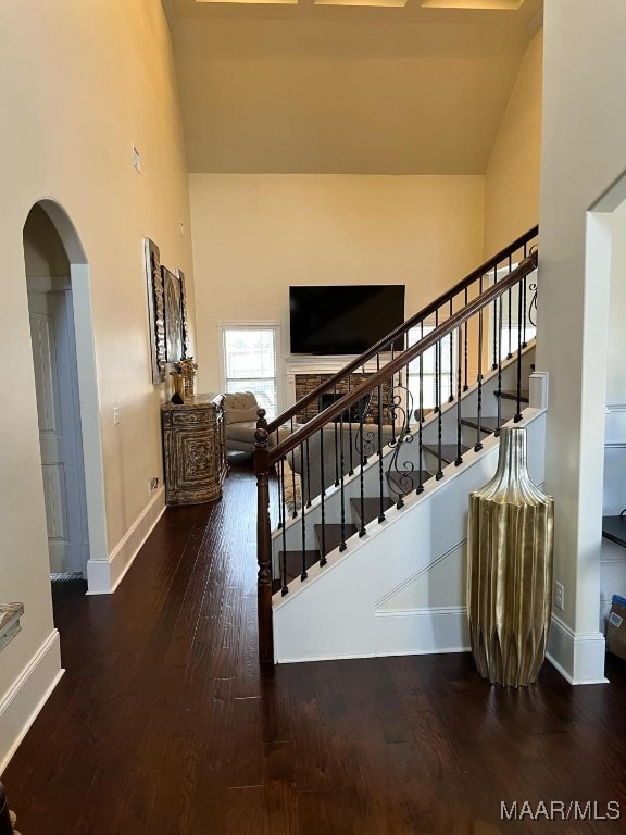 stairs featuring a high ceiling and hardwood / wood-style flooring