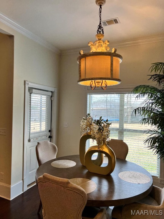 dining area with dark wood-type flooring and ornamental molding