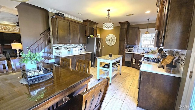 137 Scott Ln, Prattville, AL 36066 - kitchen featuring stainless steel appliances, dark brown cabinetry, tasteful backsplash, light countertops, and ornamental molding