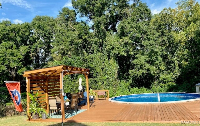 137 Scott Ln, Prattville, AL 36066 - outdoor pool with a wooden deck, a pergola, outdoor dining space, and view of wooded area