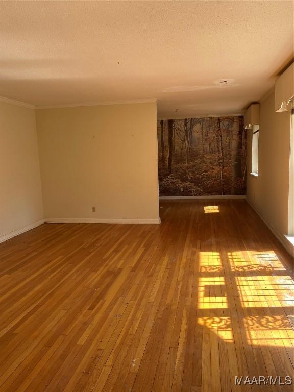 spare room with a textured ceiling and hardwood / wood-style flooring