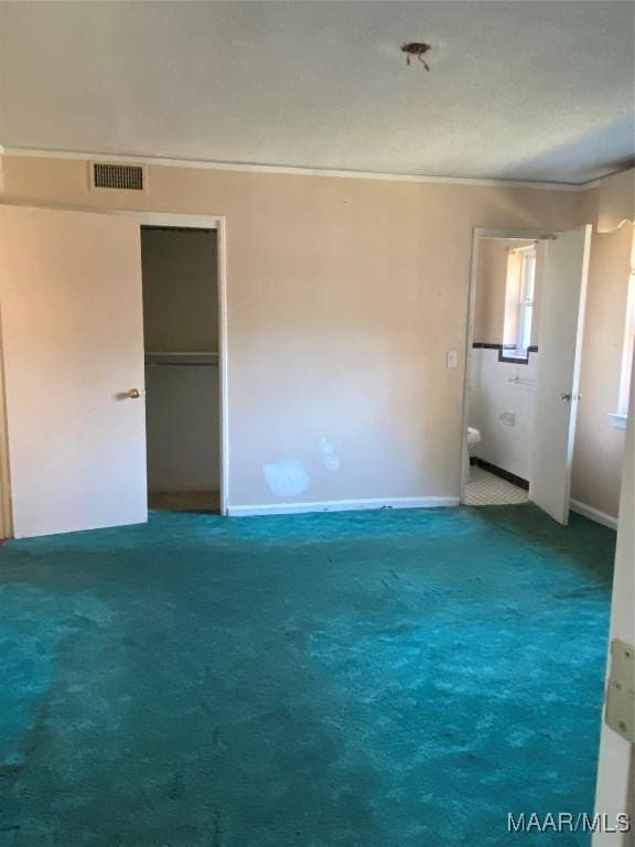 interior space featuring carpet, crown molding, and ensuite bathroom