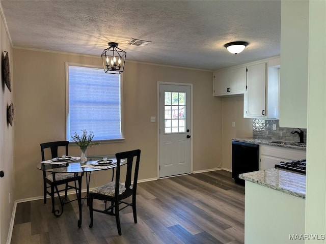 dining area with sink, ornamental molding, dark hardwood / wood-style floors, and a textured ceiling