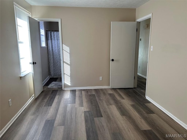 unfurnished room featuring plenty of natural light, dark hardwood / wood-style floors, and a textured ceiling