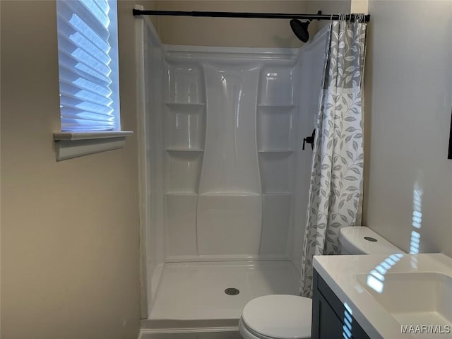 bathroom with toilet, vanity, and a shower with shower curtain