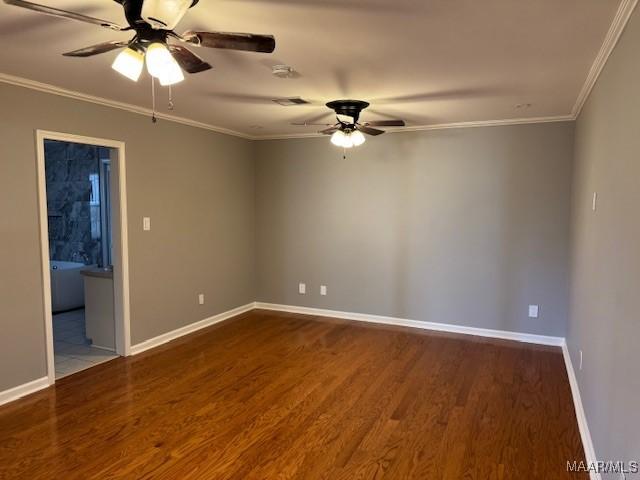 empty room featuring ceiling fan, ornamental molding, and dark hardwood / wood-style floors