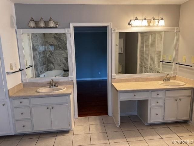 bathroom with a washtub, tile patterned floors, and vanity