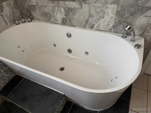 bathroom featuring tile patterned flooring and tiled tub