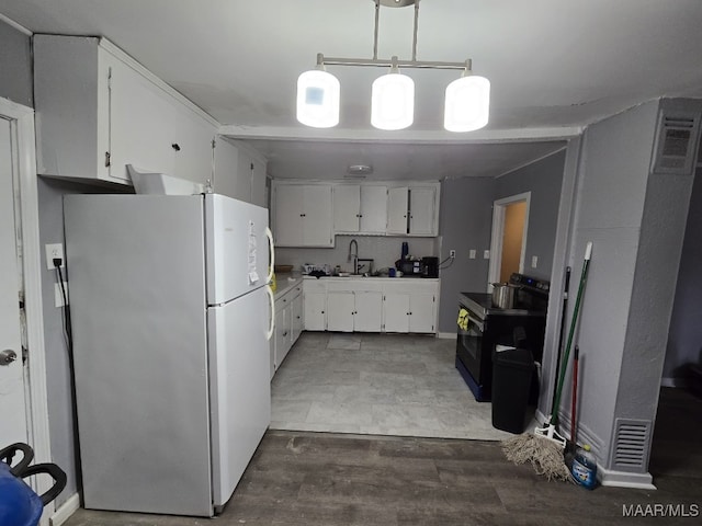 kitchen with pendant lighting, sink, white cabinets, white fridge, and black range with electric cooktop