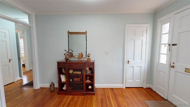 foyer entrance featuring ornamental molding and light hardwood / wood-style floors