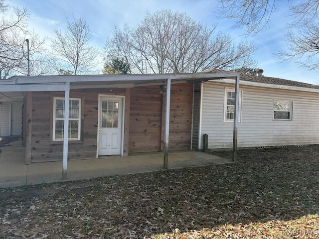 rear view of property featuring covered porch and a patio area