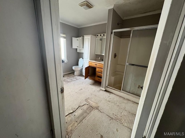 bathroom with a shower with shower door, vanity, toilet, and crown molding