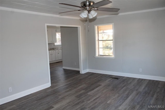 empty room with dark hardwood / wood-style flooring, a wealth of natural light, and crown molding