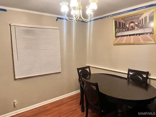 dining area featuring crown molding, an inviting chandelier, and hardwood / wood-style flooring