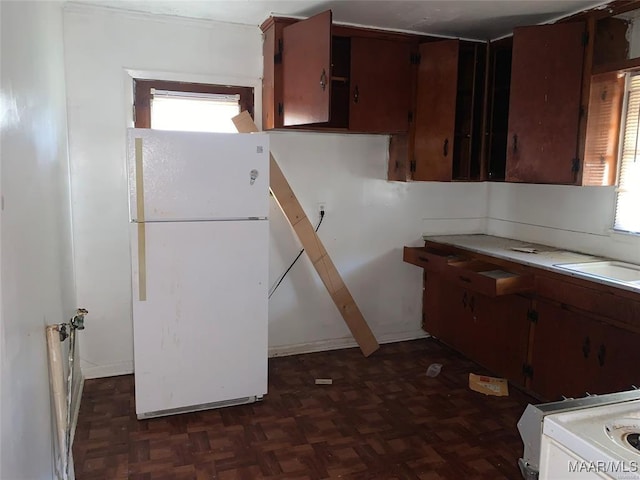 kitchen with sink, white refrigerator, dark brown cabinets, and dark parquet floors