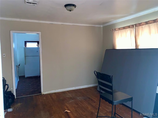 unfurnished office featuring dark wood-type flooring and crown molding