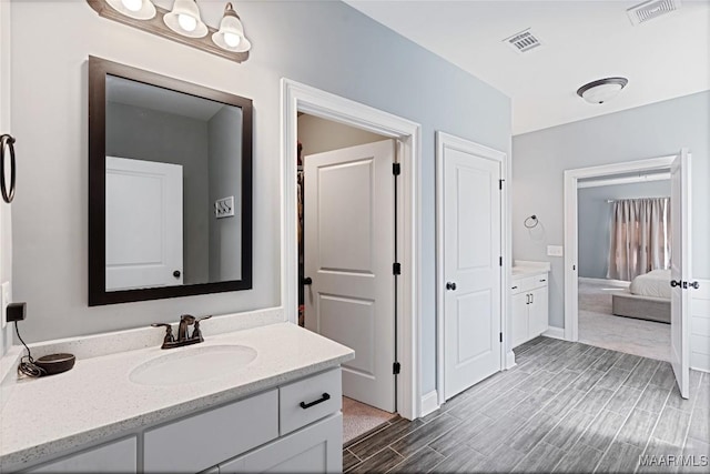 bathroom featuring wood tiled floor, visible vents, and vanity