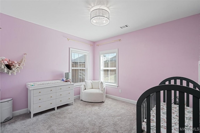 carpeted bedroom featuring a nursery area, visible vents, and baseboards