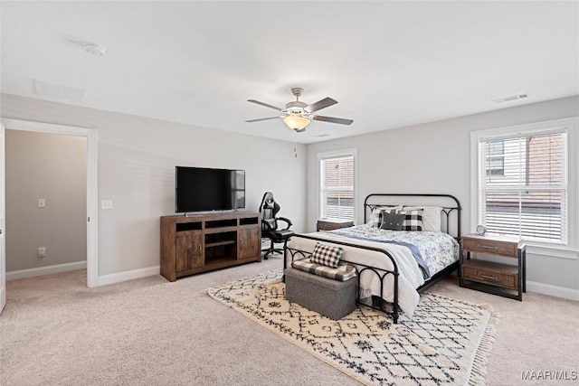 carpeted bedroom with a ceiling fan, visible vents, baseboards, and multiple windows