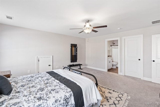 bedroom featuring carpet floors, baseboards, visible vents, and connected bathroom