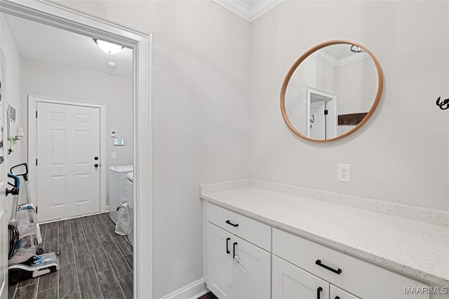 bathroom featuring wood finish floors, crown molding, vanity, and baseboards