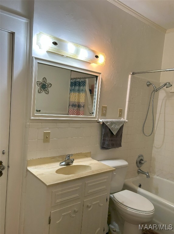 full bathroom featuring toilet, tiled shower / bath, ornamental molding, vanity, and decorative backsplash