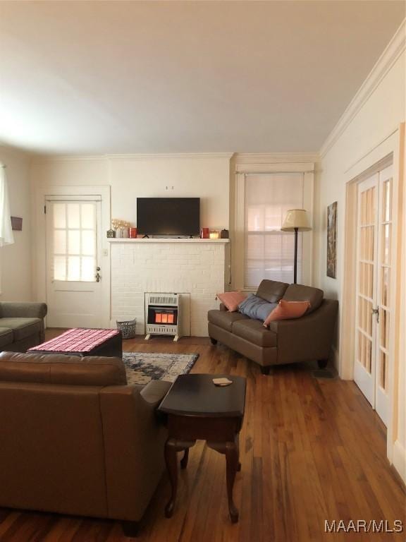 living room featuring ornamental molding, a fireplace, hardwood / wood-style floors, and heating unit