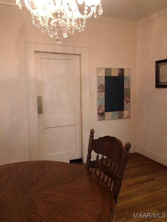 dining area featuring ornamental molding, dark hardwood / wood-style floors, and a notable chandelier