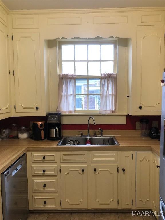 kitchen with white cabinetry, dishwasher, and sink