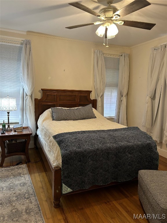 bedroom featuring ornamental molding, dark hardwood / wood-style floors, and ceiling fan