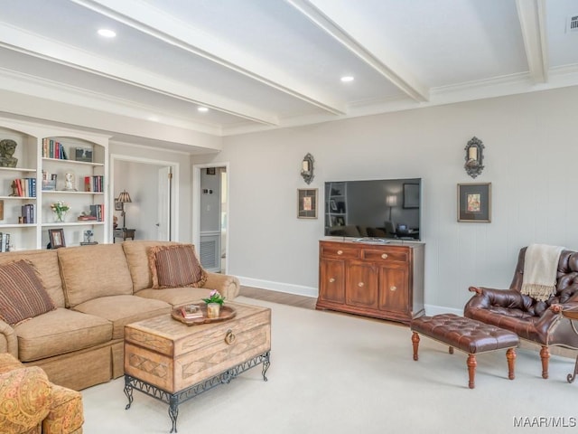 living room featuring built in shelves, beamed ceiling, and ornamental molding