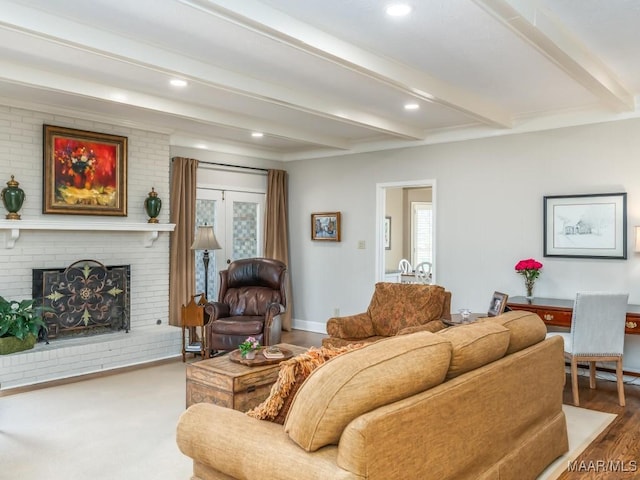 living room with hardwood / wood-style flooring, beam ceiling, and a fireplace