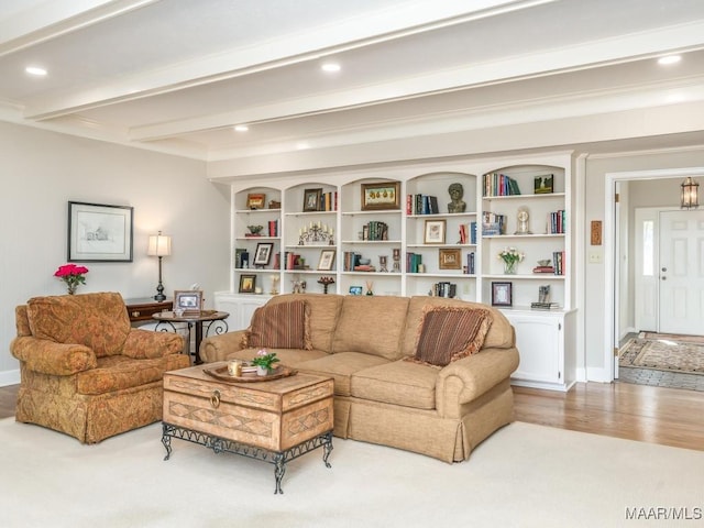 living room with built in features, beam ceiling, and light wood-type flooring