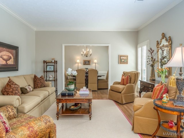 living room featuring crown molding, a chandelier, and light wood-type flooring