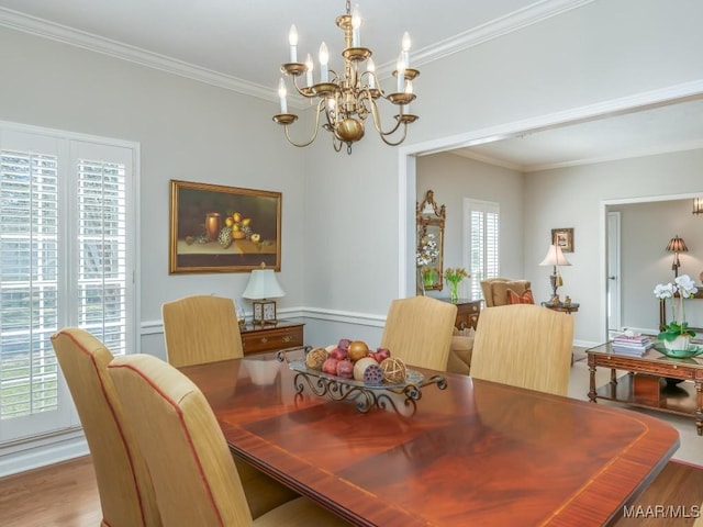 dining area featuring crown molding, an inviting chandelier, and wood-type flooring