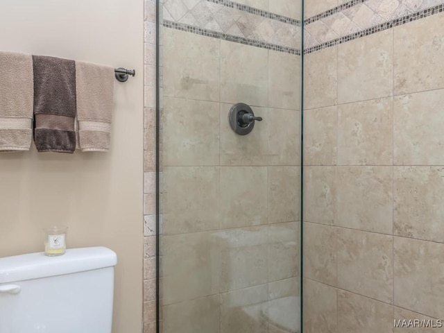 bathroom featuring tiled shower and toilet