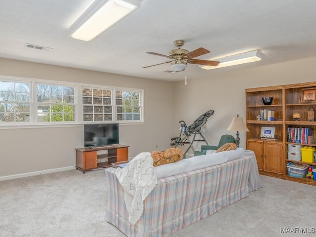 carpeted living room with ceiling fan