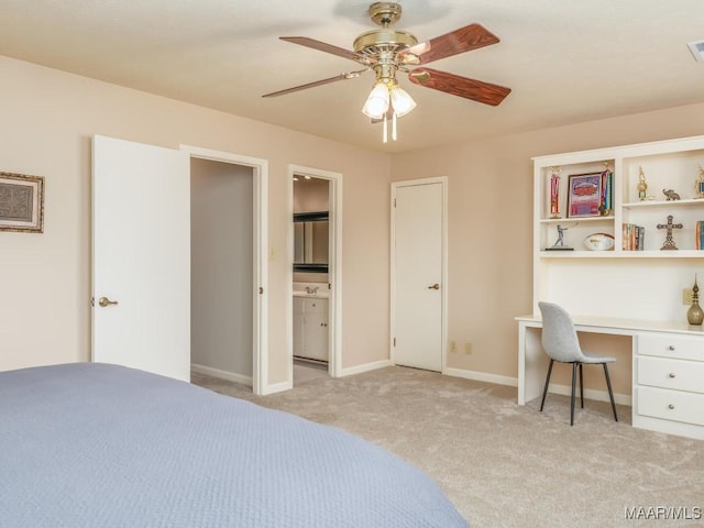 carpeted bedroom featuring ceiling fan, ensuite bathroom, and built in desk