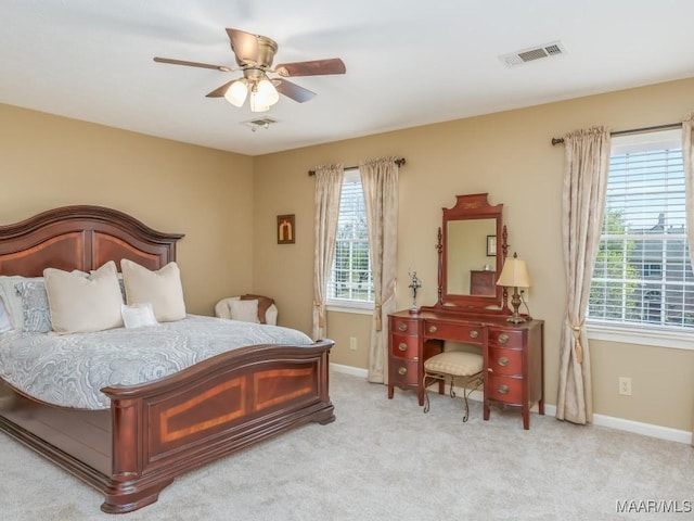 bedroom featuring light carpet, multiple windows, and ceiling fan