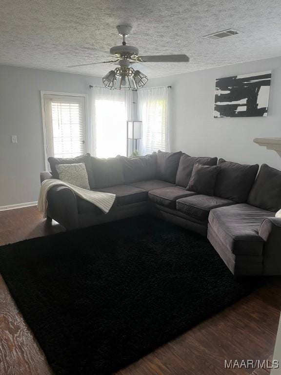 living room featuring hardwood / wood-style floors, plenty of natural light, a textured ceiling, and ceiling fan