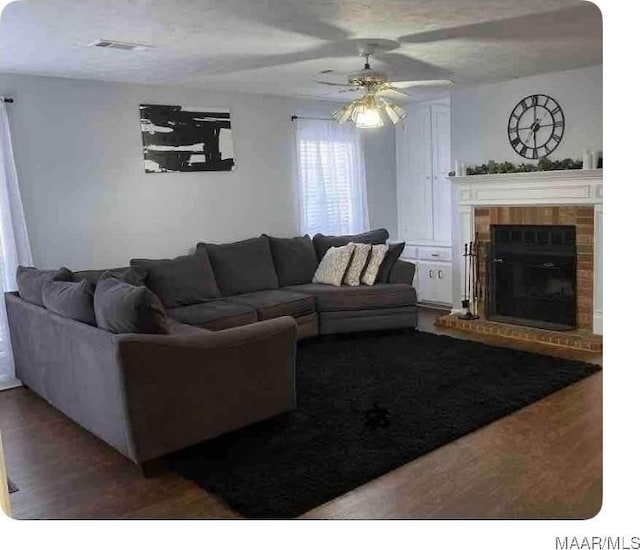 living room with ceiling fan, hardwood / wood-style floors, and a fireplace