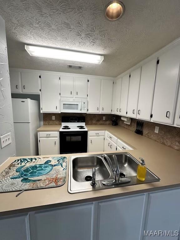 kitchen featuring a textured ceiling, white appliances, white cabinetry, and sink