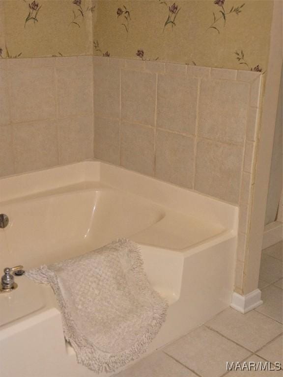 bathroom with tile patterned flooring and a tub to relax in