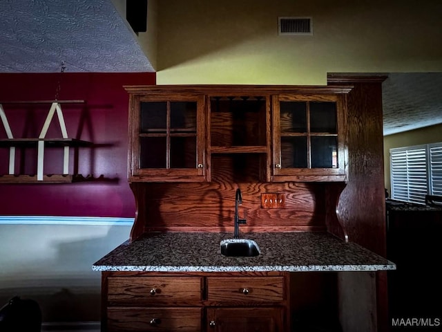 3601 Richardson Rd S, Hope Hull, AL 36043 - kitchen featuring dark stone counters, glass insert cabinets, and dark brown cabinetry