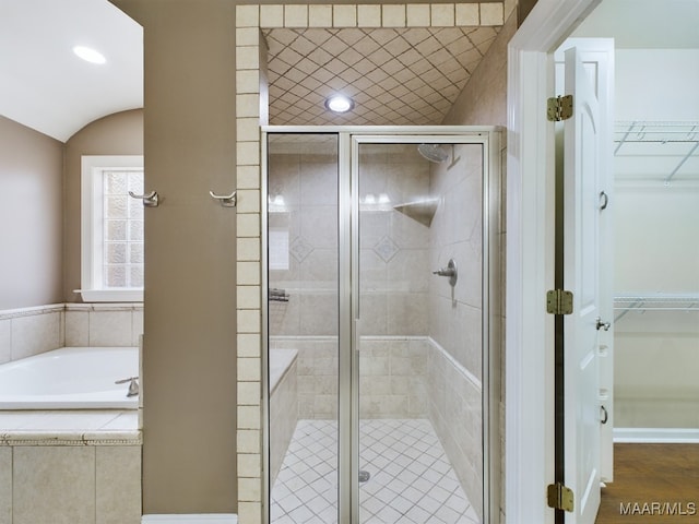 bathroom featuring independent shower and bath and vaulted ceiling